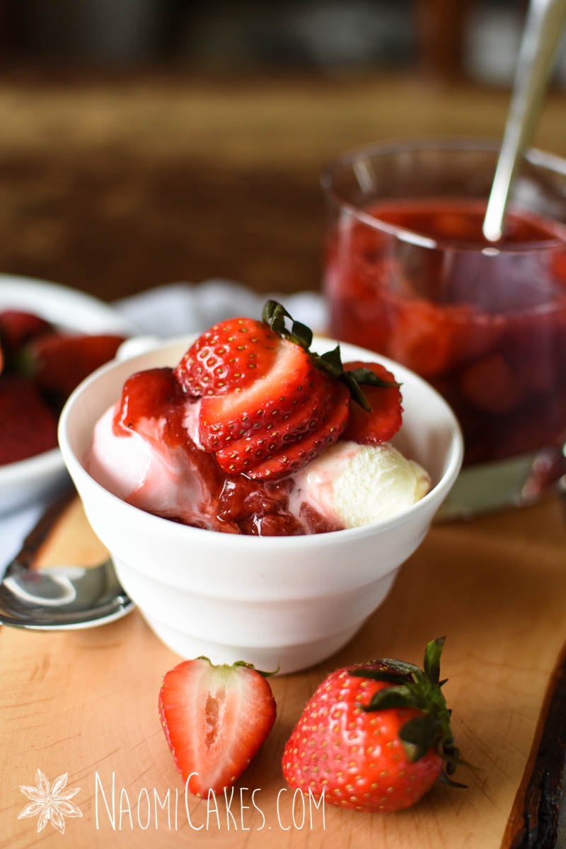 white teacup with strawberry, vanilla and chocolate ice cream with strawberry sauce and fresh strawberries
