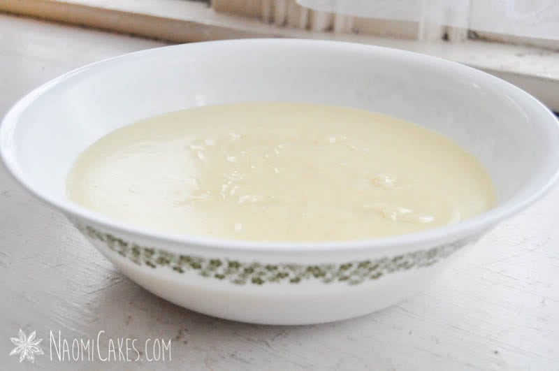 bowl of vanilla pudding on a wooden table