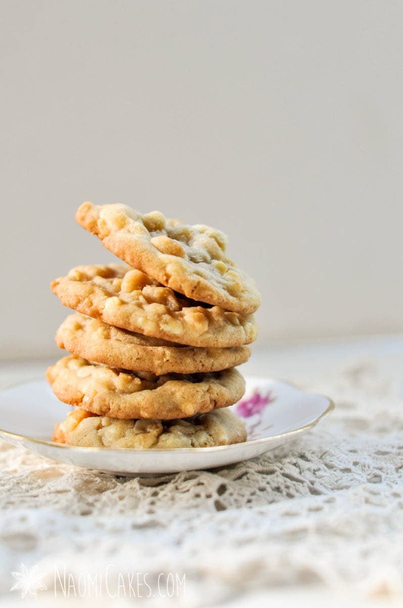 close up of white chocolate macadamia nut cookies in a stack on a tea saucer