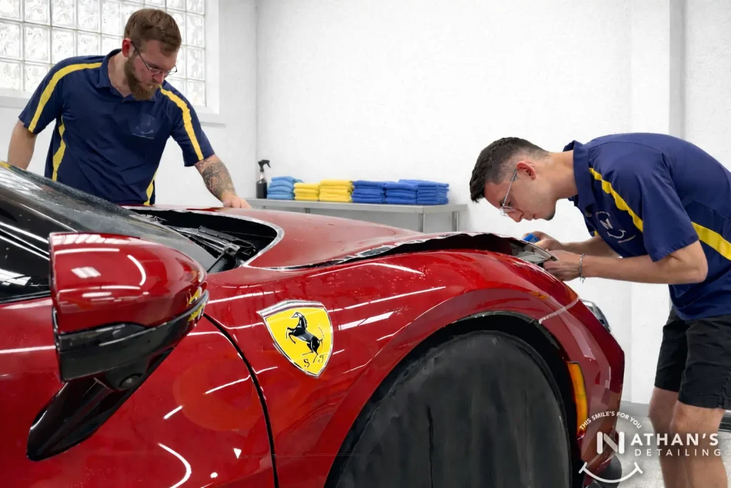 XPEL-certified technician installing PPF on a red Ferrari at Nathan's Bedford studio