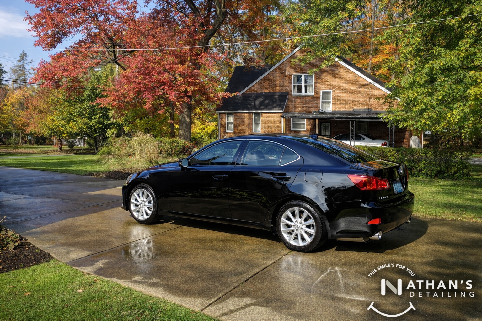 Black sedan glossy paint on wet driveway during mobile detailing in Green