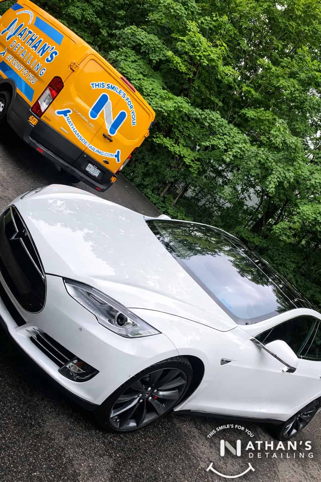White Tesla photographed from the front angle with Nathan's mobile detailing van