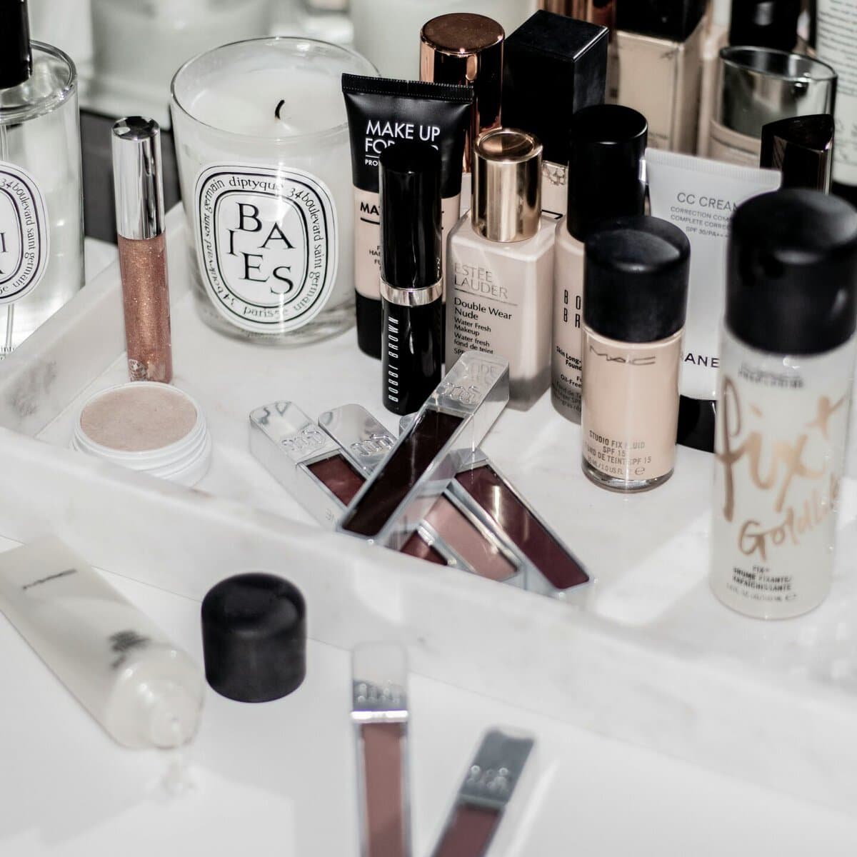 A makeup vanity table topped with beauty and skincare products
