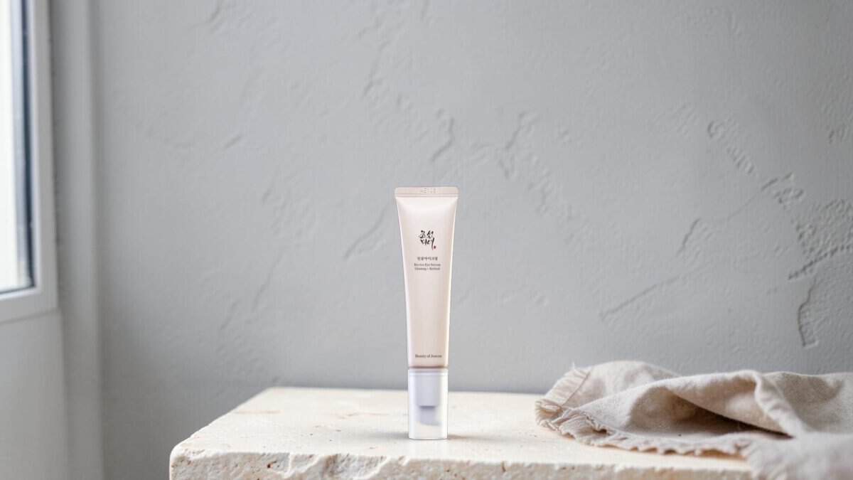 Beauty of Joseon Revive Eye Serum on a stone shelf against a grey plaster wall with a linen cloth
