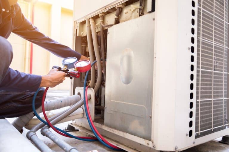 Professional technician servicing an air conditioning unit to ensure peak performance.