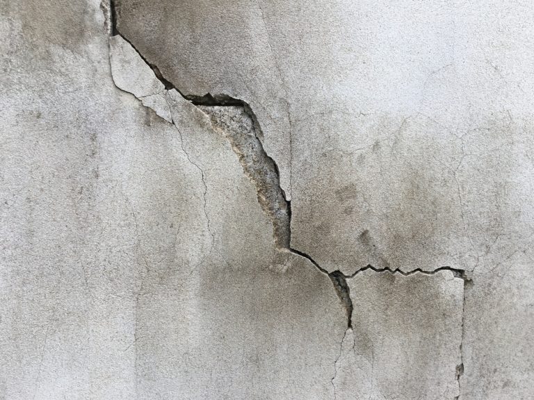 A weathered wall with a prominent crack, revealing the passage of time.