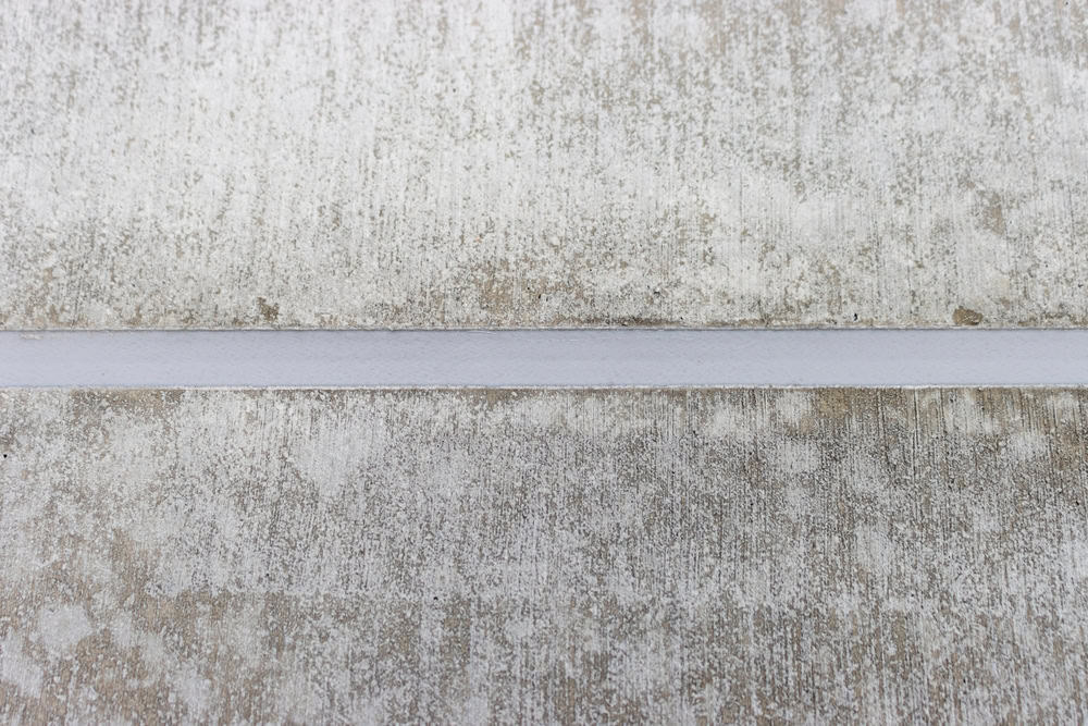 A weathered, textured surface with a subtle horizontal line running through it.