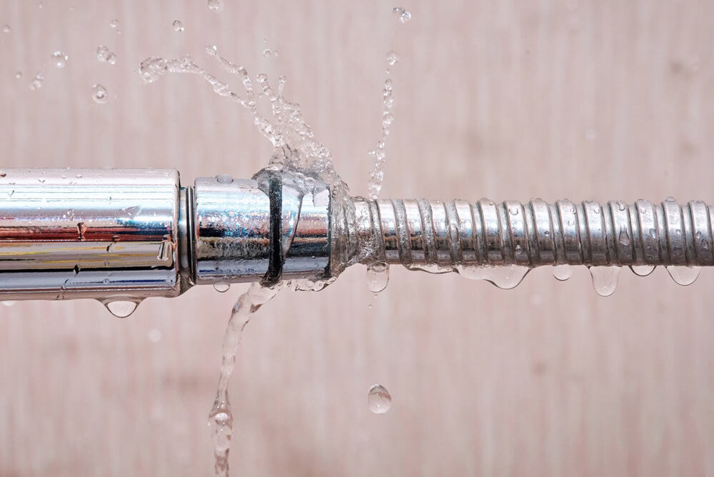A leaky faucet sprays water, highlighting the need for a repair.