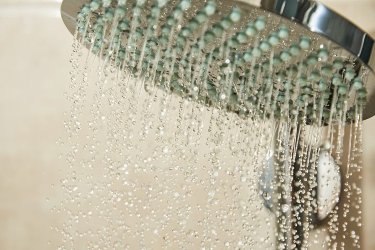 Water cascades from a modern showerhead, creating a refreshing and serene atmosphere.