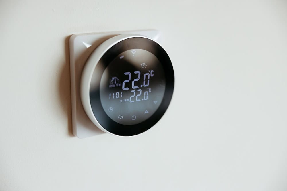 A modern smart thermostat set to 22°C keeps the room perfectly comfortable.