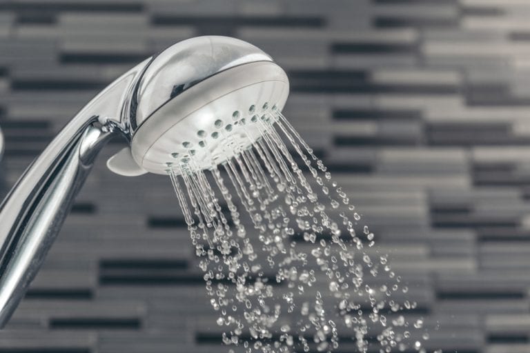 A refreshing shower spray captured in motion against a sleek, modern bathroom backdrop.
