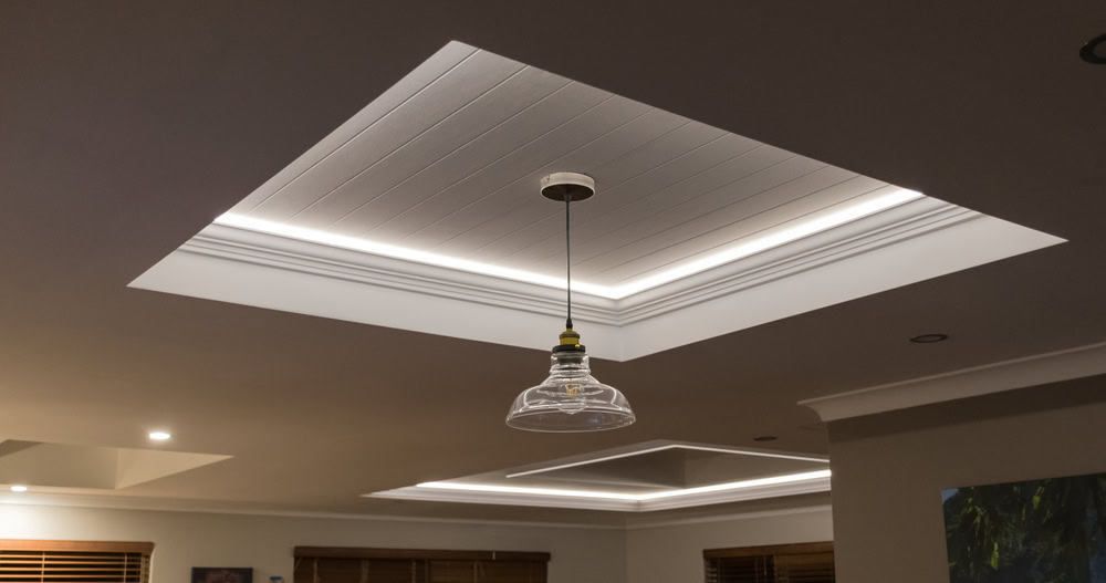 Modern ceiling design with a glass pendant light and recessed lighting.