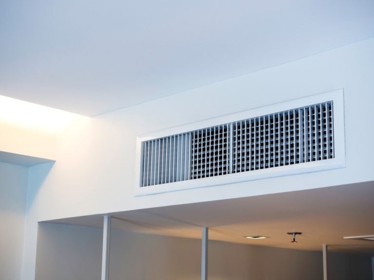 A modern ceiling vent in a minimalist room.