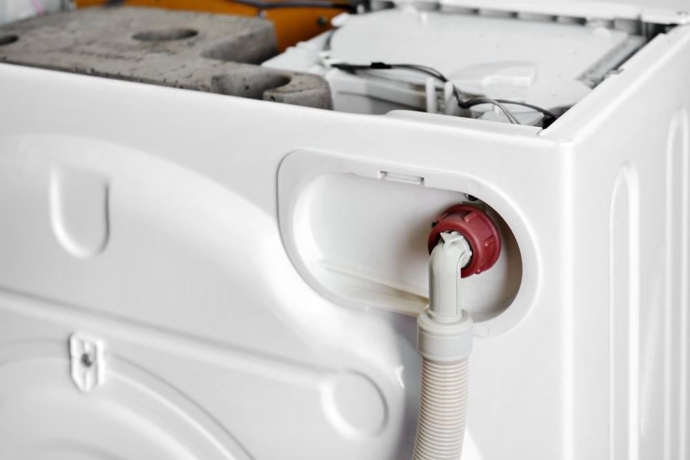 Inside the workings of a washing machine, showcasing the drainage hose connection.