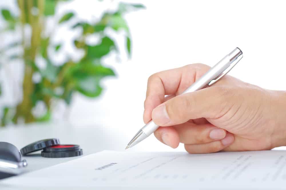 Signing important documents in a calm, green office space.