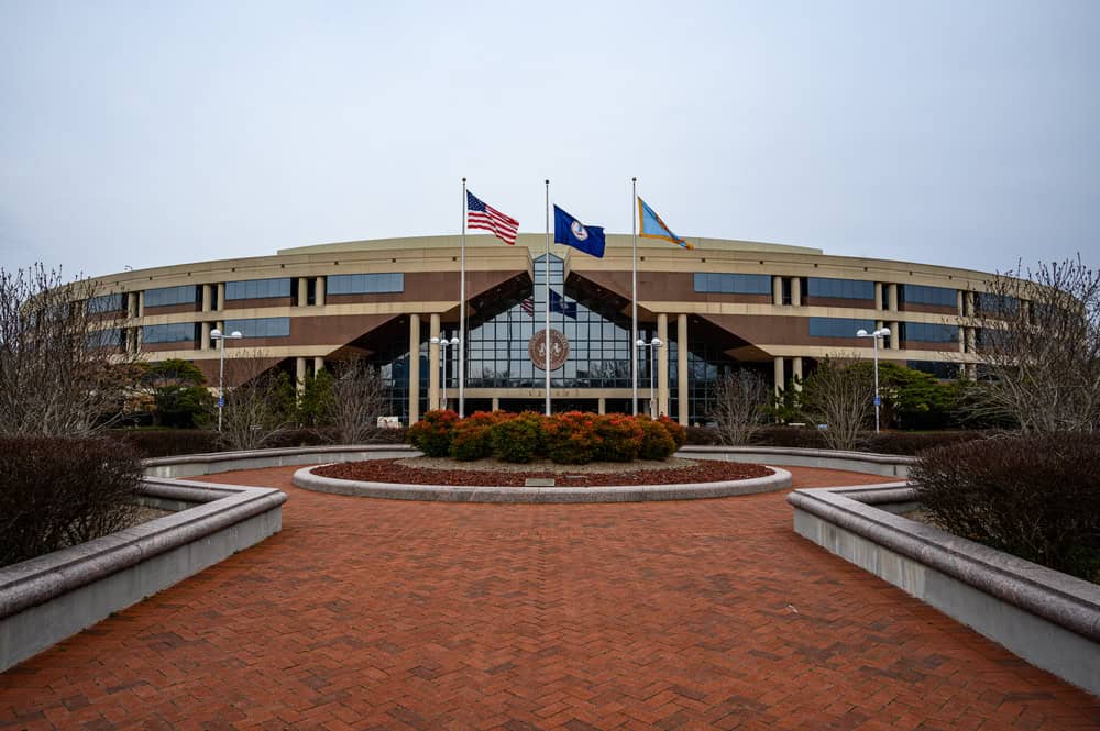 The Fairfax County Government Center, framed by flags and a landscaped entrance.