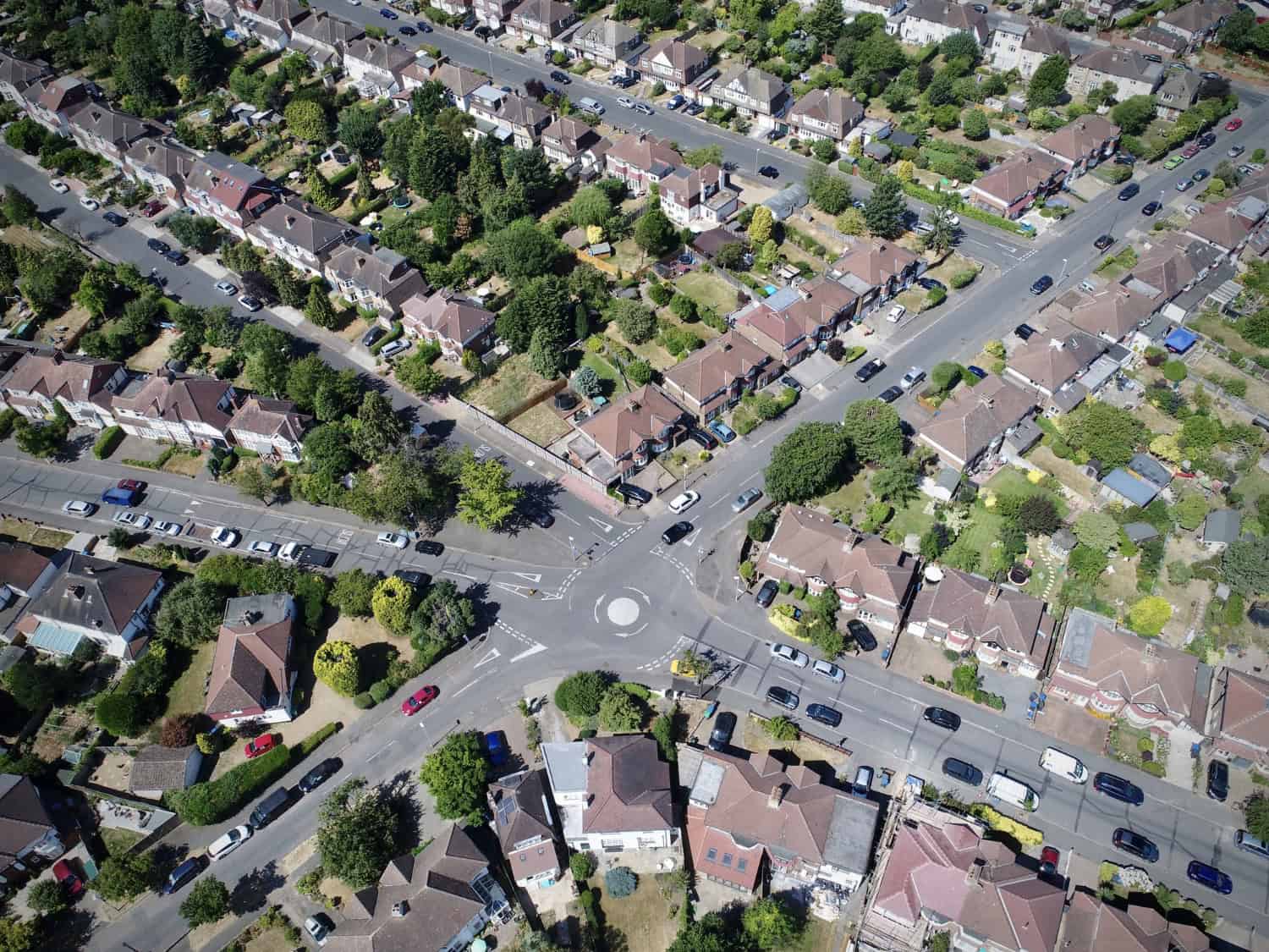 A picturesque aerial view of a suburban neighborhood and its tidy streets converging at a charming roundabout.