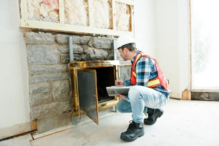An inspector checking a fireplace during a home inspection