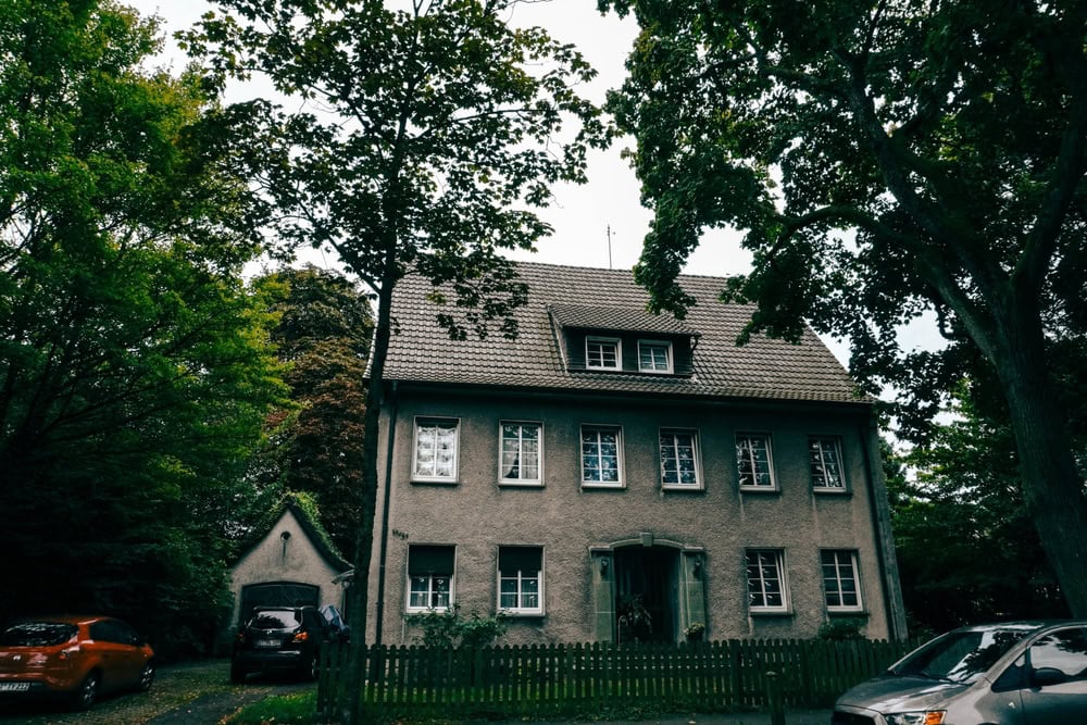 A charming old house surrounded by lush greenery, exuding a peaceful, timeless atmosphere.