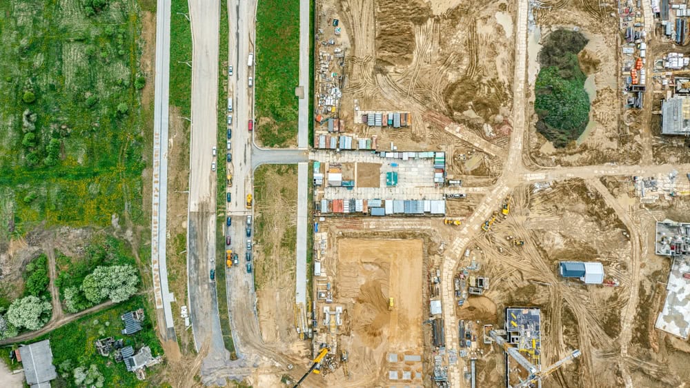 Aerial view of a bustling construction site, where roads and buildings take shape amidst a landscape of dirt, machinery, and progress.