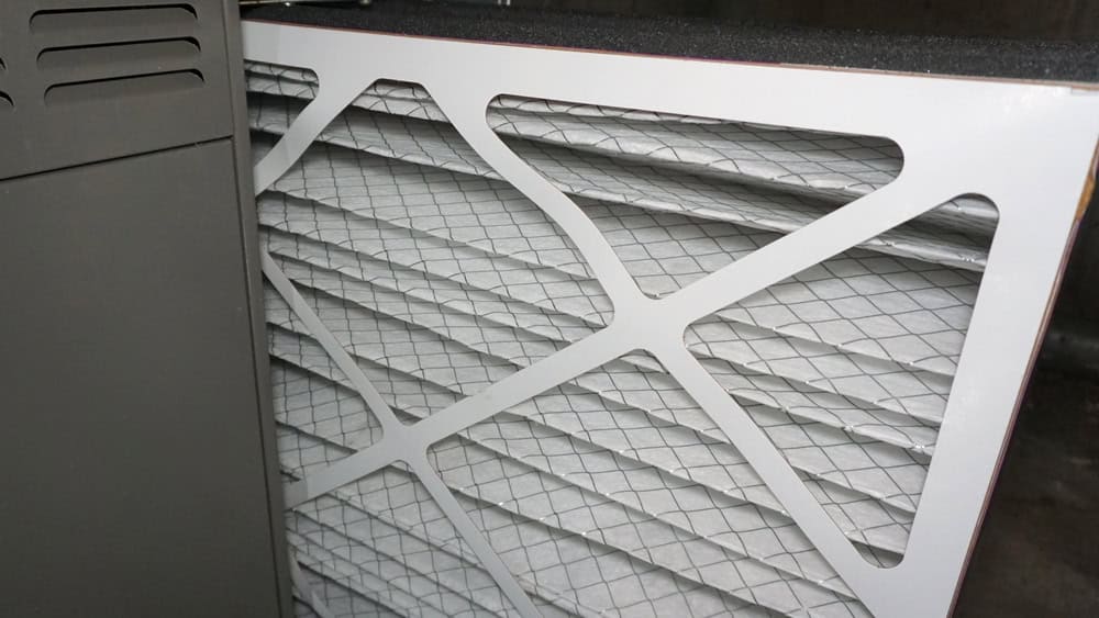 A stack of clean furnace filters ready for installation.
