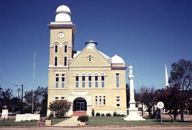 A historic courthouse with a clock tower, arched entrance and domed roof.