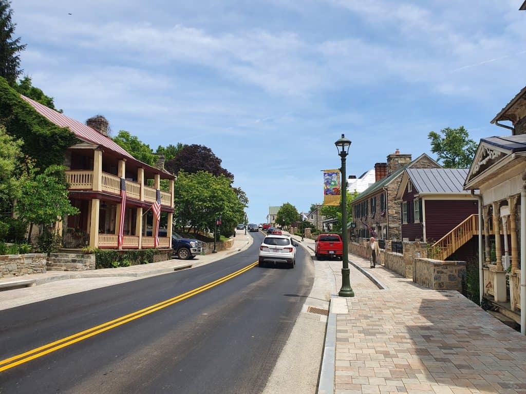 A two story porch house and stone buildings line a small town street in Hillsboro, Virginia