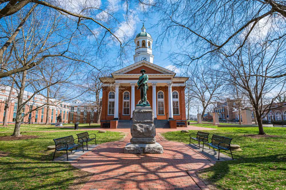 A bronze soldier statue stands before the brick Loudoun County Courthouse in Leesburg, Virginia