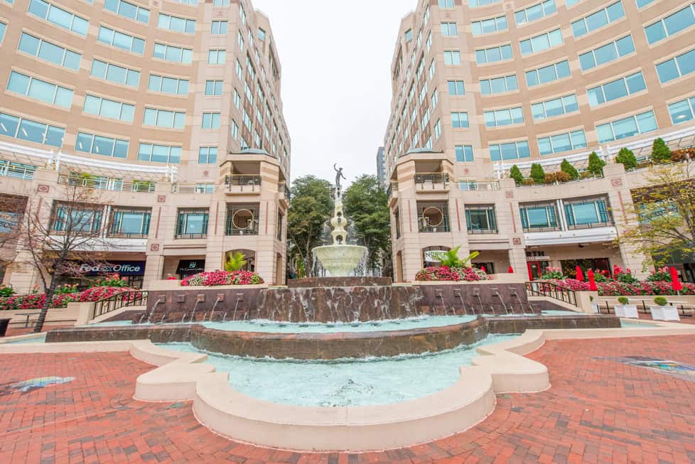 The fountain plaza at Reston Town Center, flanked by tall office and retail buildings.