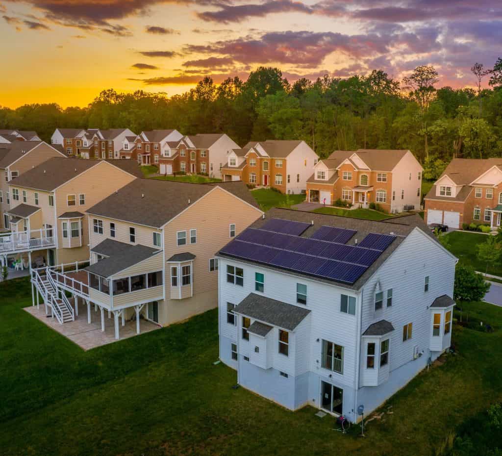 An aerial view of a suburban neighborhood with houses and a colorful sunset sky in Columbia, Maryland.