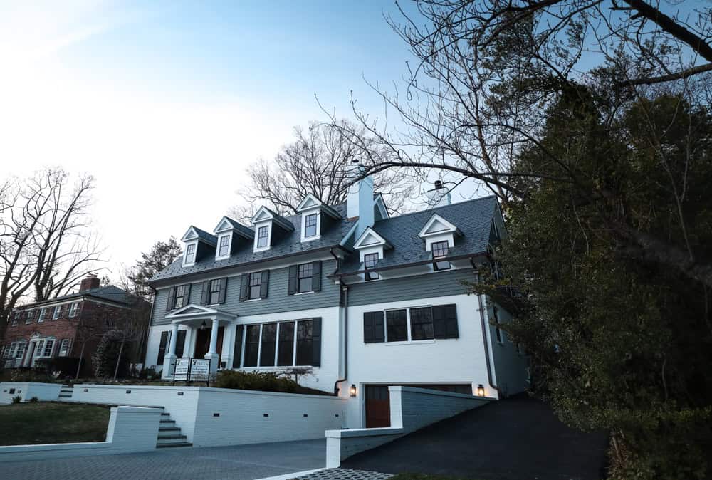 A large house with dormer windows and a lower-level garage