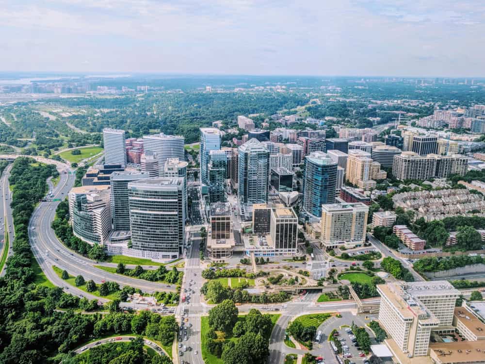 Aerial view of office and apartment towers beside a river.