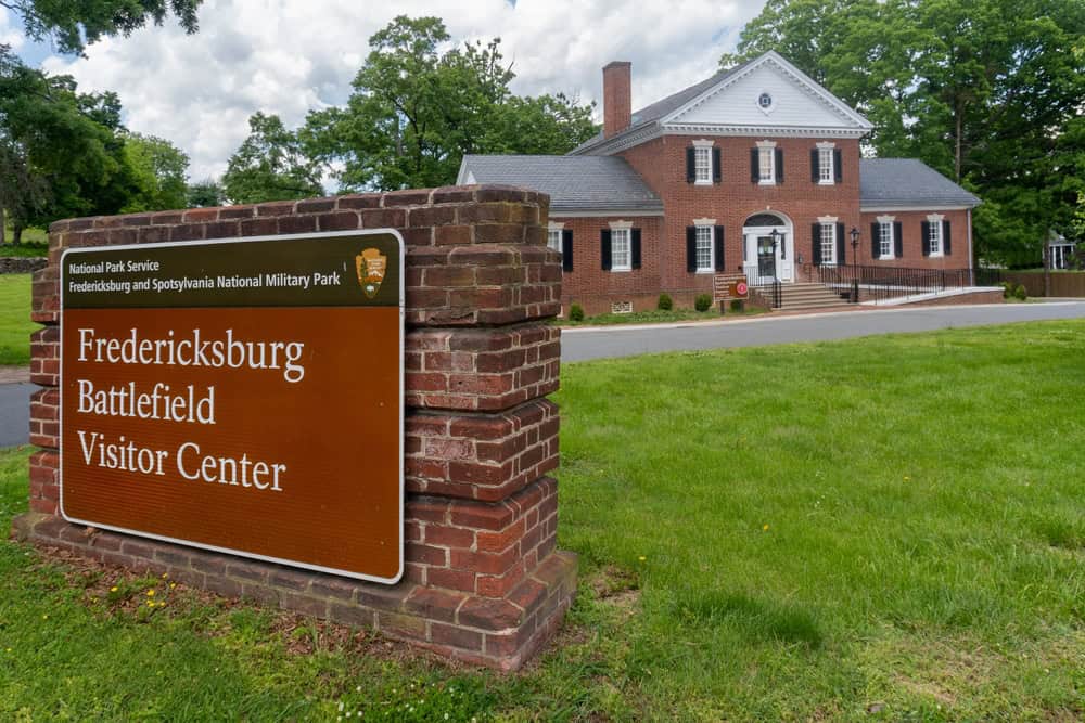 Fredericksburg Battlefield Visitor Center entrance sign beside a brick building.