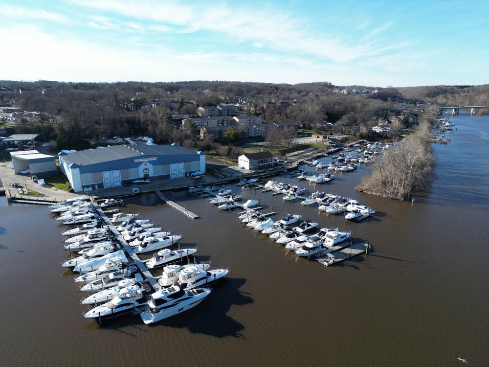 Aerial view of a marina full of docked boats with homes among trees in the background near Lake Ridge, Virginia