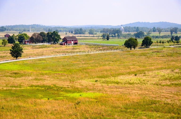 Open farmland with a red barn and distant memorials at Gettysburg, Pennsylvania