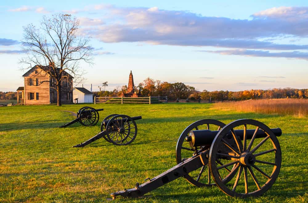 Civil War cannons and a wooden farmhouse on the battlefield in Prince William County, Virginia