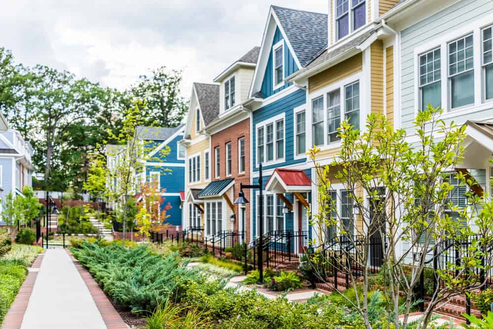 A row of brightly colored attached townhouses with covered entries along a walkway in Laurel, Maryland