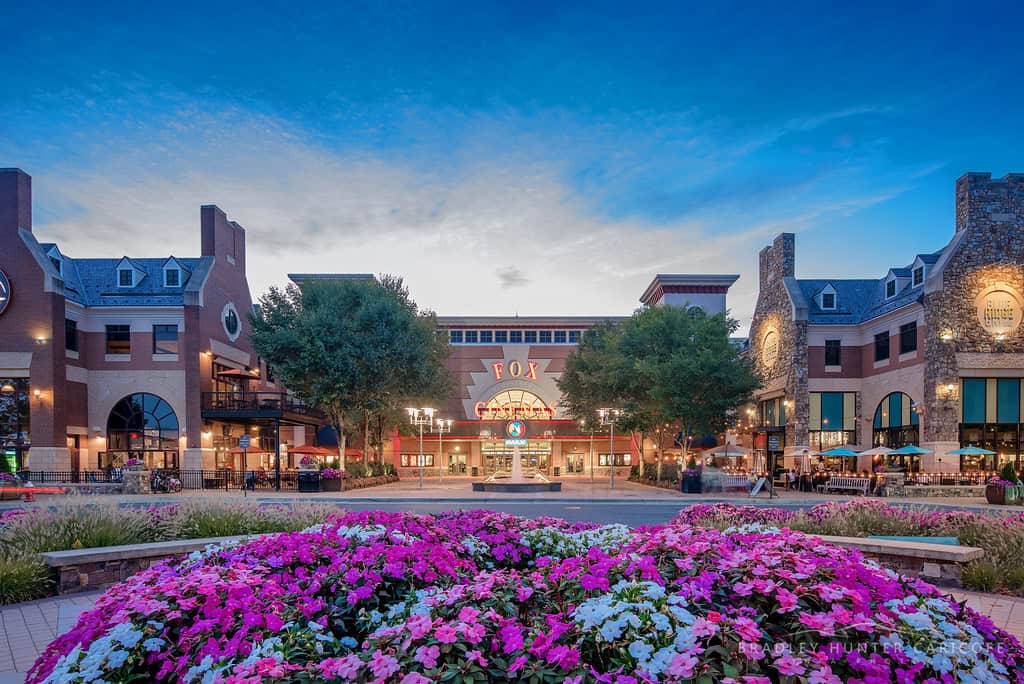 Flower beds lead to the lit marquee of the Fox theater at Brambleton Town Center in Virginia