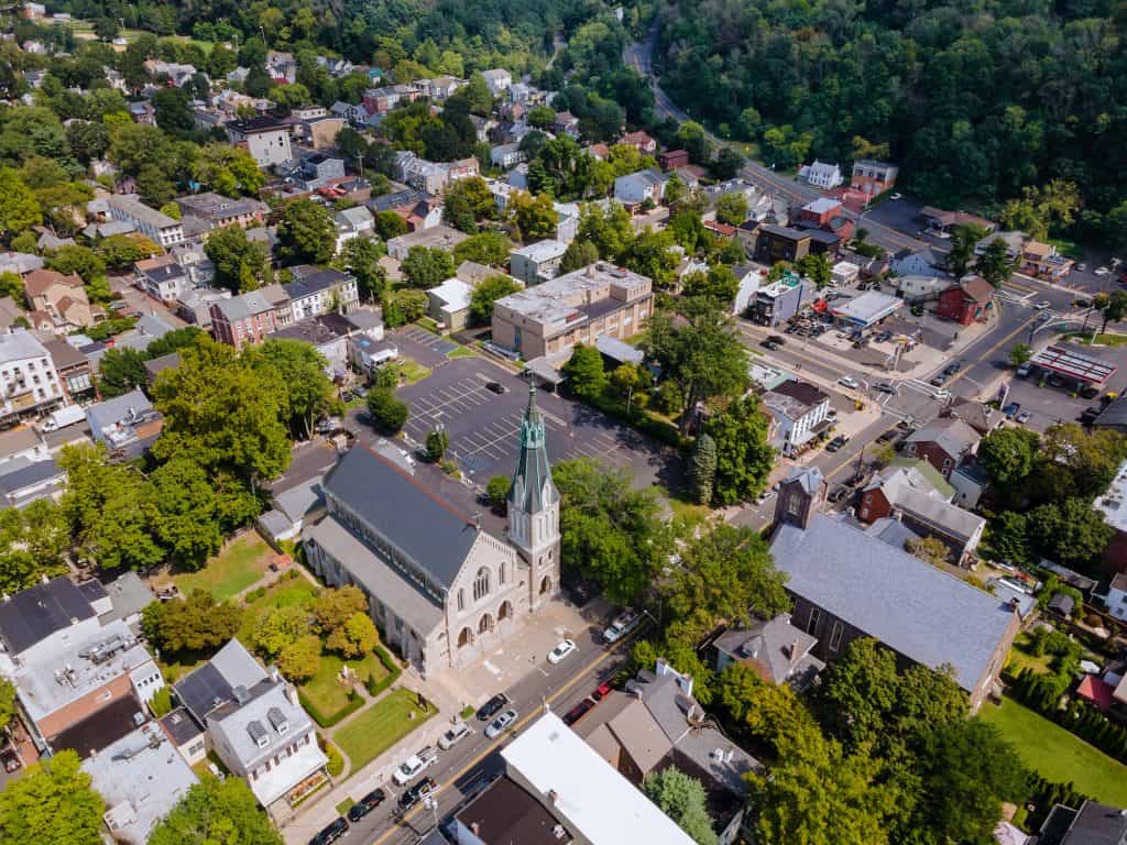An aerial view centered on a church steeple surrounded by rooftops and trees in Greencastle, Pennsylvania