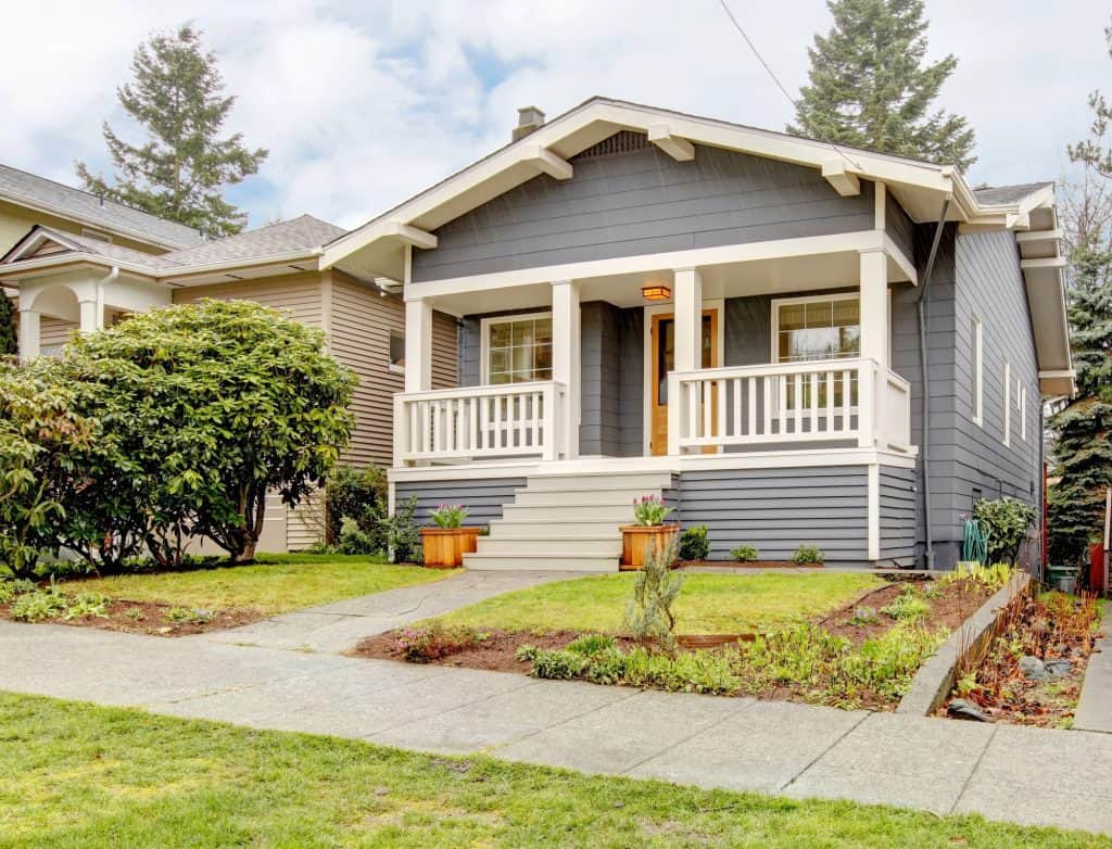 A gray craftsman bungalow with a covered front porch and white columns in Turkeyfoot, Pennsylvania