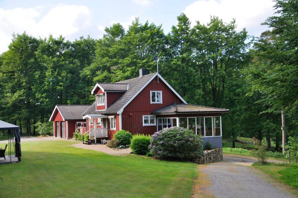 A red house with white trim on a wooded, grassy lot in Biglerville, Pennsylvania.
