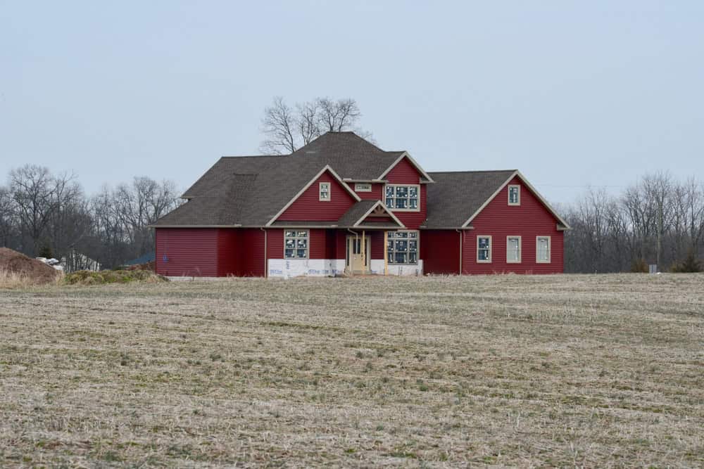 A large red house under construction in an open field with bare trees, near Chambersburg, Pennsylvania
