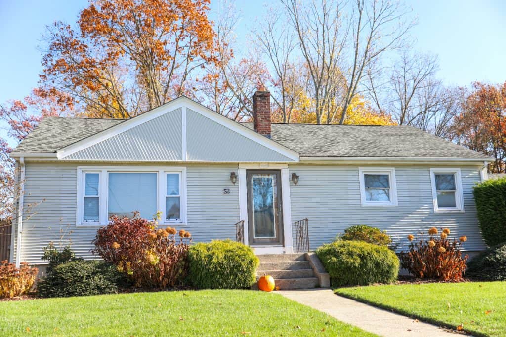A single-story house with a front lawn in autumn