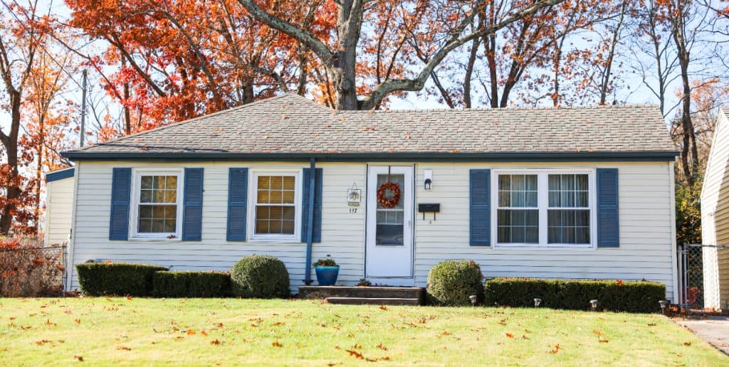 A single-story house with blue shutters in autumn