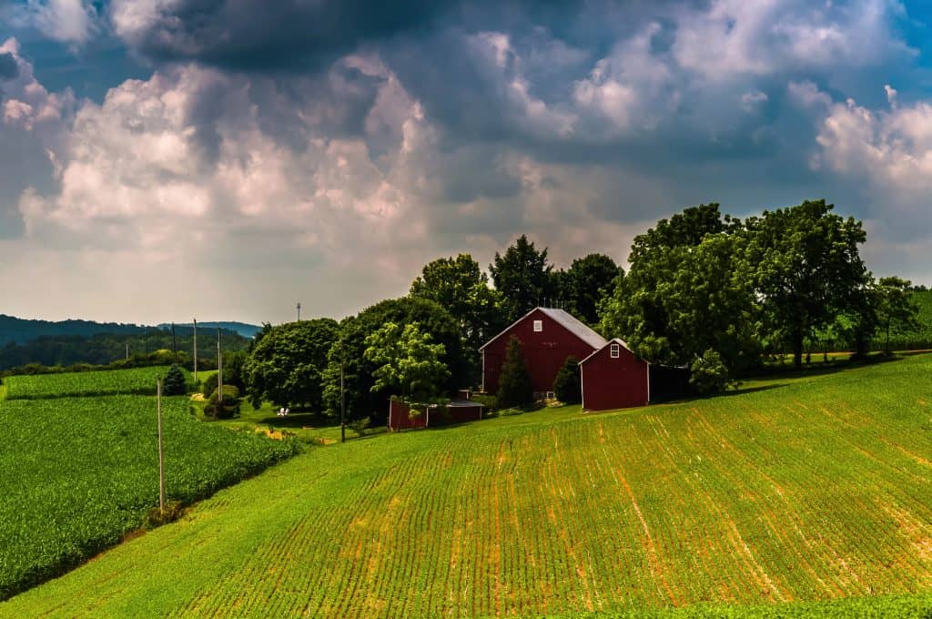 A red barn surrounded by green fields under a stormy sky near Red Lion, Pennsylvania
