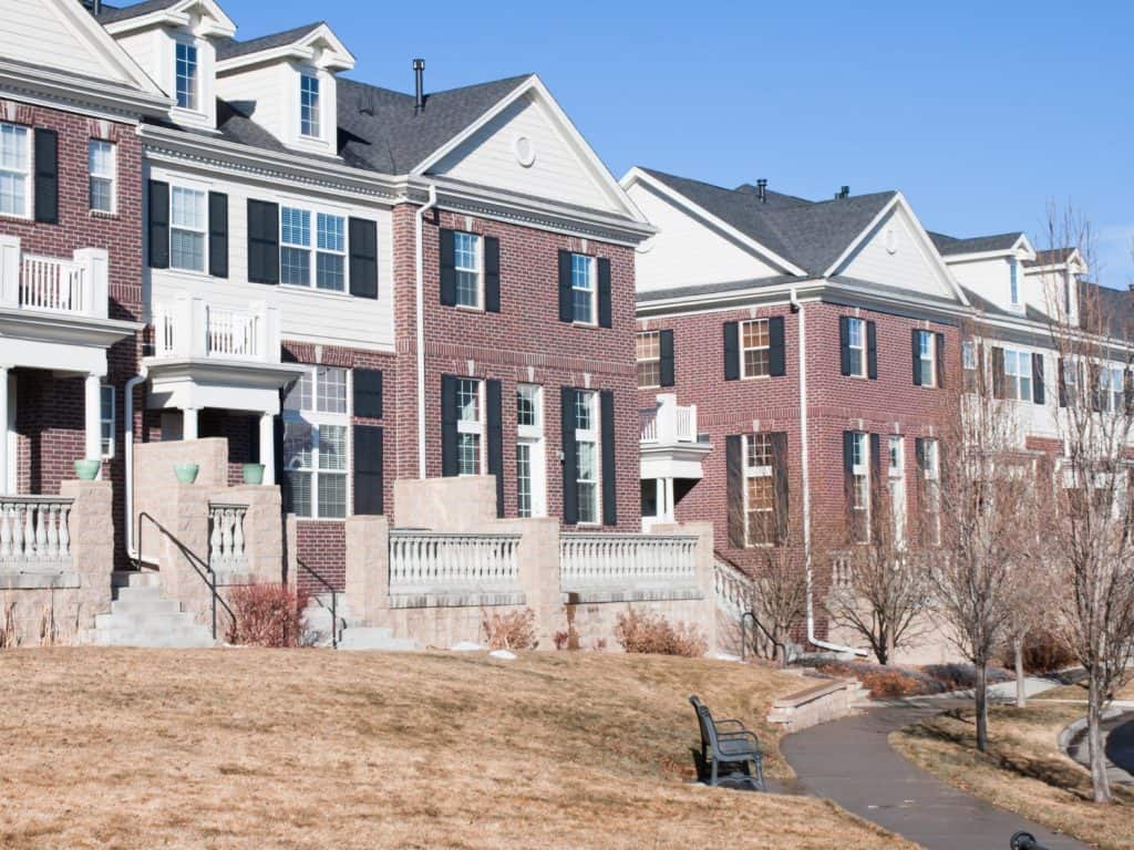 Rows of brick townhomes with black shutters along a walking path in McNair, Virginia.