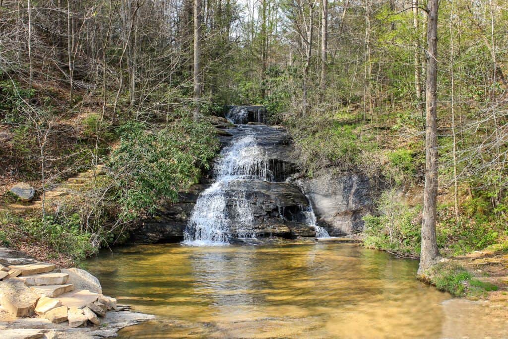 A multi-tiered waterfall cascading over dark rock into a pool in a forest near Idylwood, Virginia.