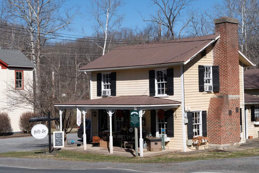 A brick storefront with a covered porch and benches in Clifton.