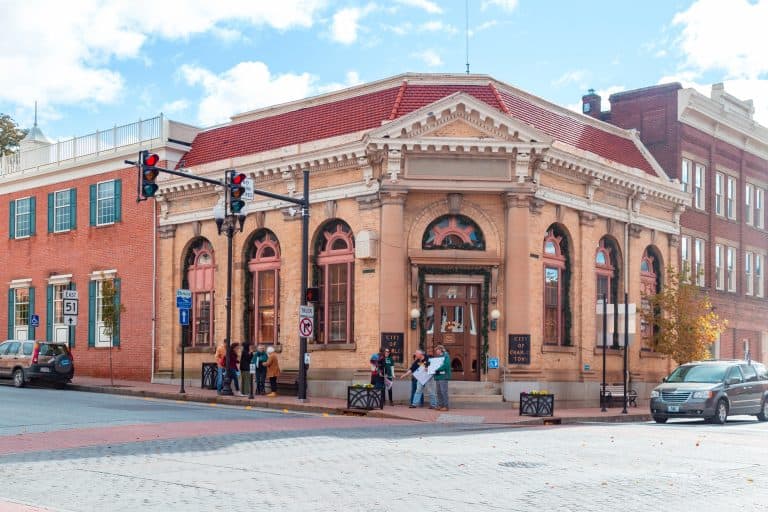 A historic brick building with arched windows and a red tile roof in downtown Charles Town, West Virginia.