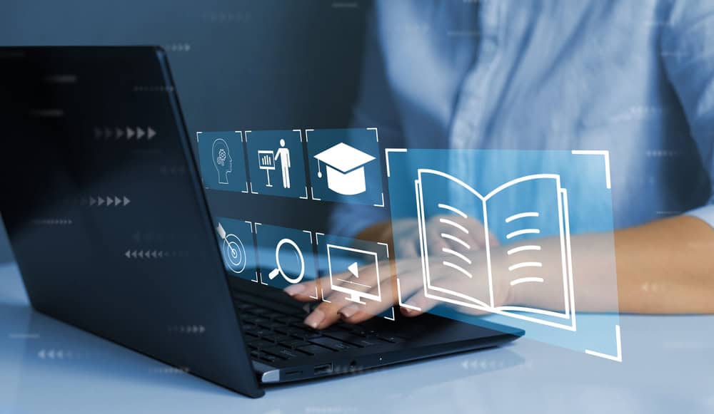 A person engages in online learning, exploring virtual education icons and digital resources on their laptop.